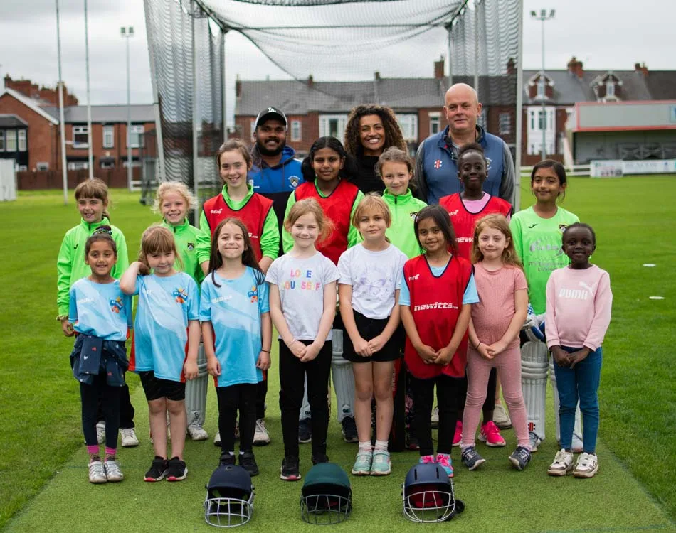 People grouped together on cricket pitch